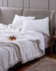 The Celestial Sky Bedspread, a luxurious handwoven cotton creation, showcases delicate hand-embroidered star motifs scattered across its soft, textured surface. The gentle fringe detailing along the edges adds an airy, ethereal touch, making it the perfect layer for a serene and inviting bedroom.