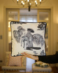 A handcrafted cushion, featuring the Heritage Threads Cushion Cover depicting a black and white Mughal elephant procession, from Idli by Thierry Journo. A fusion of heritage craftsmanship and contemporary design, each piece tells a unique story.