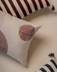 Ember Glow Cushion Cover – A striking cotton cushion cover featuring bold, hand-block-printed stripes in warm earthy tones. Finished with elegant tassels and wooden bead detailing, this artisanal piece adds depth and texture to any space, celebrating traditional craftsmanship with a modern aesthetic.