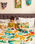 A handcrafted quilt titled The Forest is My Playground, featuring a vibrant jungle scene with hand-painted and stitched details. The quilt showcases playful monkeys swinging through lush green foliage, majestic cheetahs moving gracefully, and a toucan perched beneath oversized tropical leaves. The intricate design, rich in color and texture, is set against a soft cream background, bringing warmth and liveliness to any space.