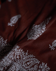 The Chambi Bedspread in Brown and White, a masterpiece of Kashmiri craftsmanship. Handwoven with care and adorned with delicate hand embroidery, its rich brown base is intricately decorated with traditional white paisley and floral motifs. A luxurious textile that embodies the artistry and heritage of Kashmir.