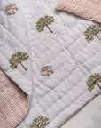 The Trees of Wonder Quilt, crafted from handwoven cotton, features intricate hand-block printed tree motifs that evoke a sense of natural serenity. The soft, quilted texture offers warmth and comfort, while the reversible striped pattern adds versatility to its timeless design. A perfect blend of artistry and coziness for an inviting bedroom.