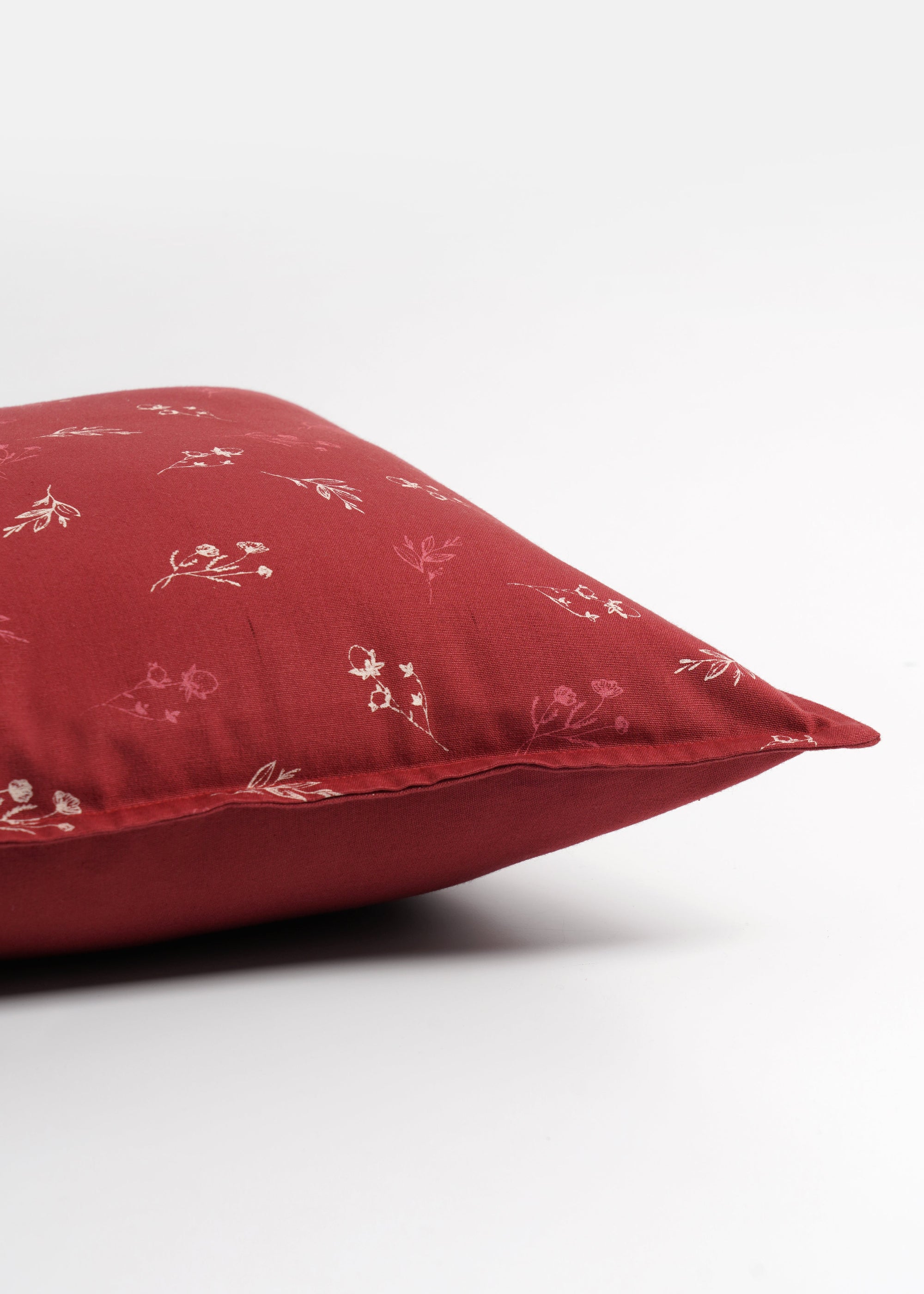  Cushion Cover – A charming cotton cushion cover in a deep red hue, delicately block-printed with floral motifs. The soft, breathable cotton fabric and traditional hand-block printing technique bring warmth and character, making it a perfect accent piece for cozy, timeless interiors