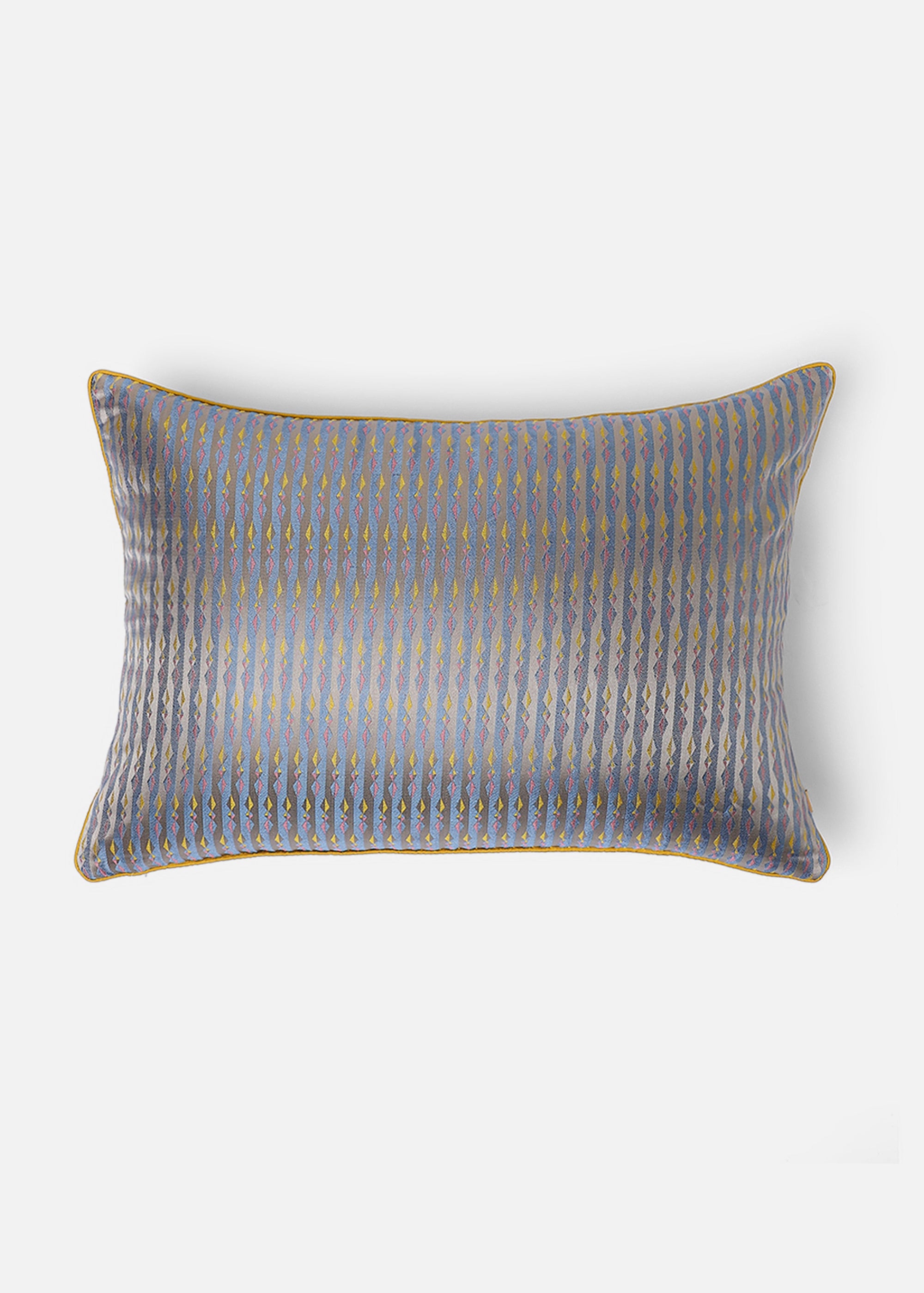 Mehira Silk Cushion Cover – A striking silk cushion cover woven with intricate geometric patterns in deep blue, gold, and maroon hues. The shimmering silk fabric catches the light, revealing a rich interplay of textures and tones. Expertly handcrafted, this cushion cover embodies the finesse of traditional weaving, adding an elegant and sophisticated touch to any space.
