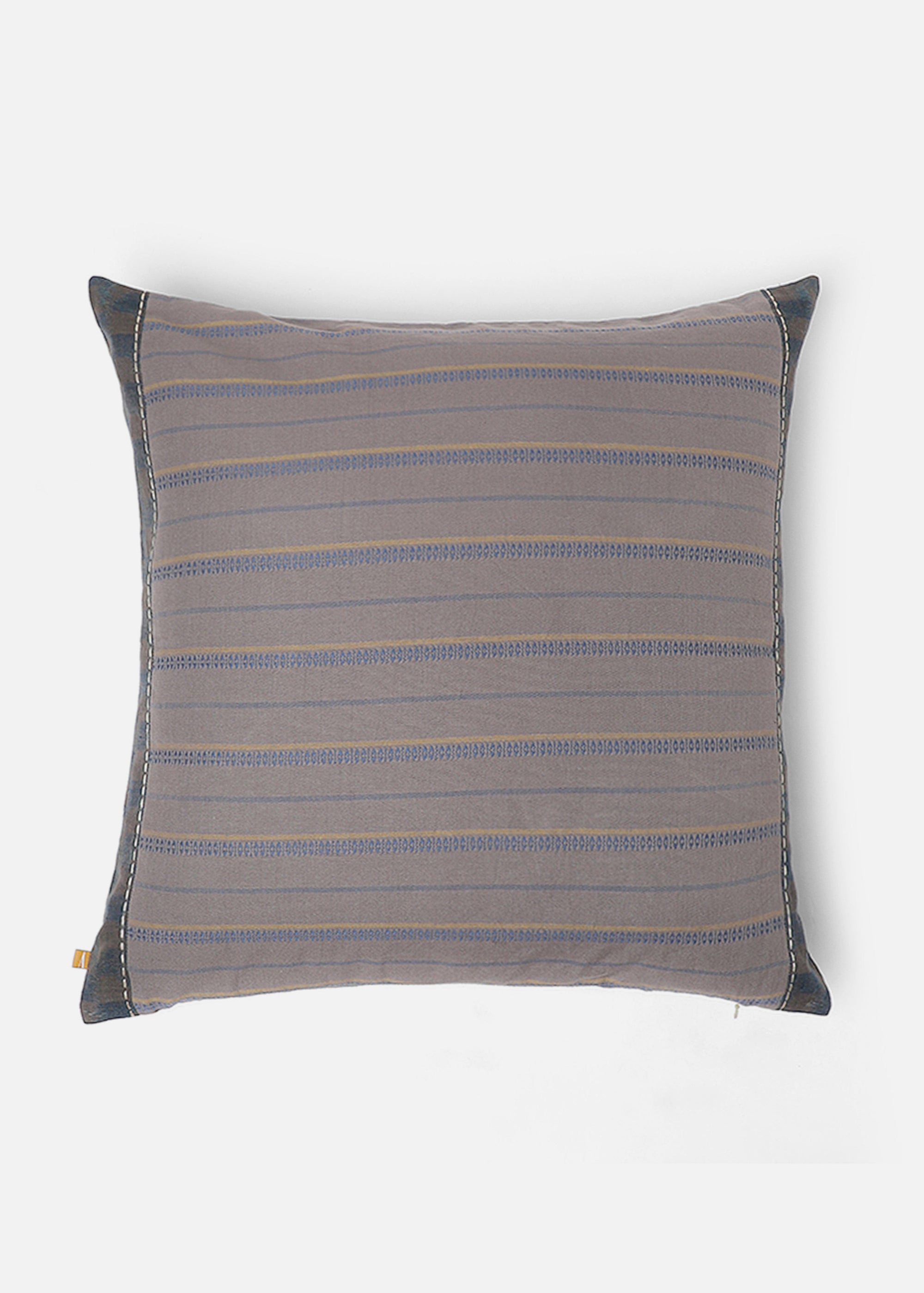 Sofia Cushion Cover – A beautifully handwoven cotton cushion cover featuring a subtle ikat-inspired pattern in warm, earthy tones of yellow, grey, and burgundy. Finished with delicate hand-stitched detailing and a contrasting dark-hued border, this piece embodies craftsmanship and understated elegance. Perfect for adding texture and character to any living space.
