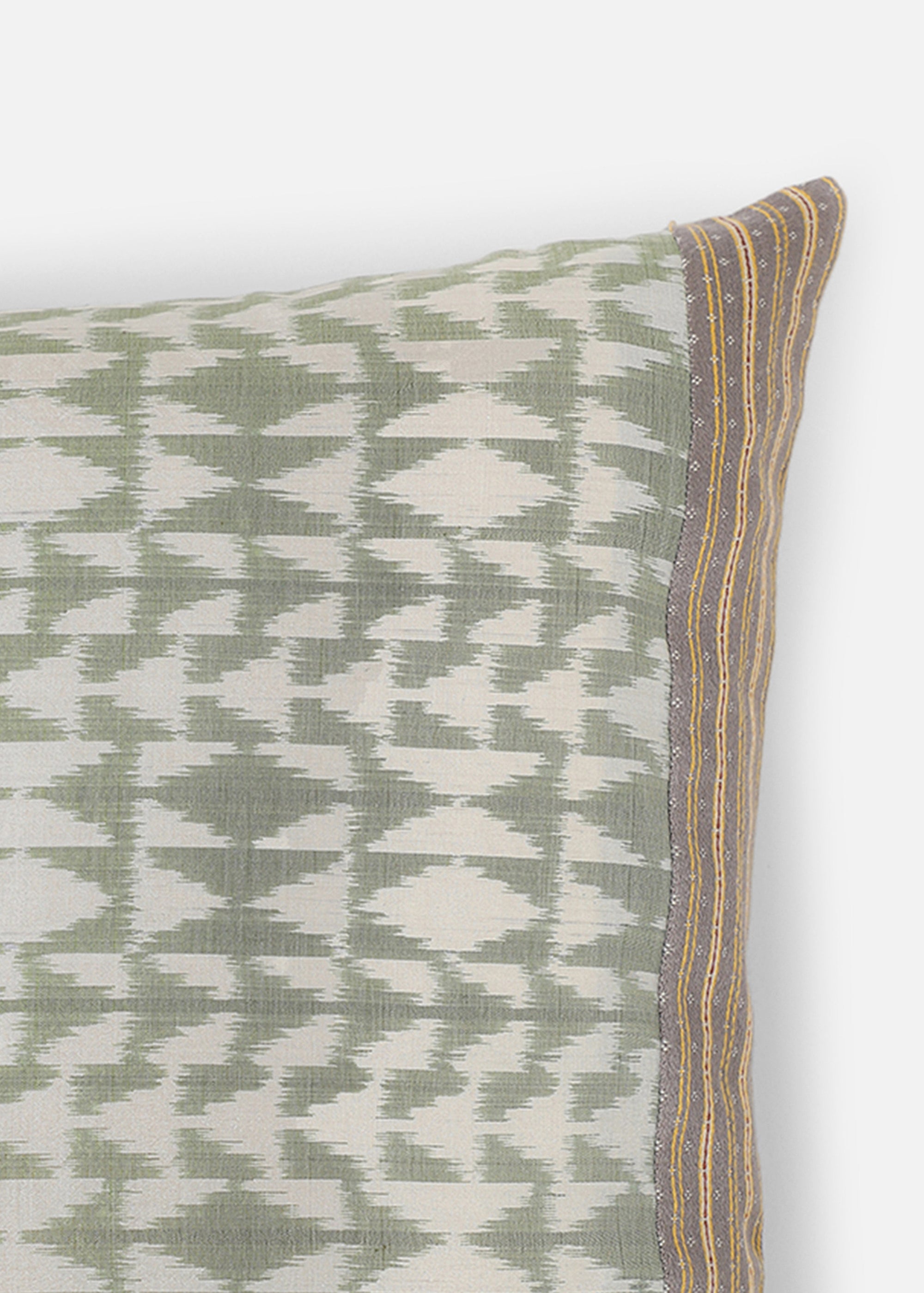 Vivia Cushion Cover – A refined blend of silk and cotton, this cushion cover showcases an intricate ikat-inspired pattern in soft sage green and ivory. Handwoven with exceptional craftsmanship, its delicate striped borders add a touch of elegance. A versatile piece that enhances both contemporary and traditional spaces.