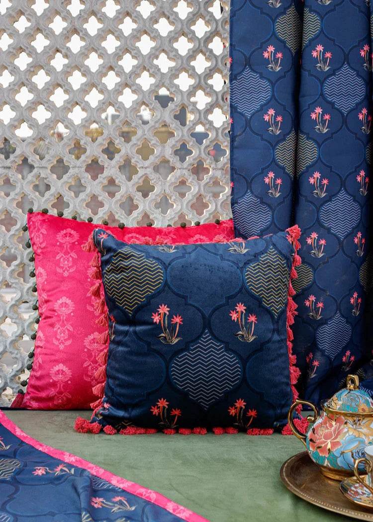 Nargis Cushion Cover – A luxurious fusion of cotton and velvet, this cushion cover features an intricate floral and geometric motif in rich navy blue, highlighted with delicate pink accents. Handcrafted with exceptional detail, its plush texture and vibrant tassel edging add a regal charm to any space.