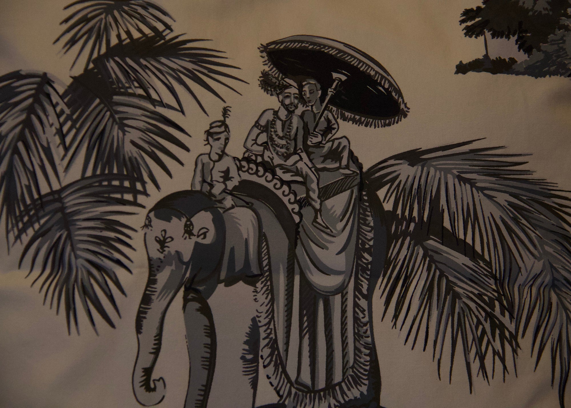 A handcrafted cushion, featuring the Heritage Threads Cushion Cover depicting a black and white Mughal elephant procession, from Idli by Thierry Journo. A fusion of heritage craftsmanship and contemporary design, each piece tells a unique story.