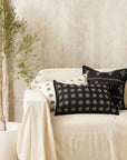 Tara Bloom Cushion Cover – A sophisticated black cushion cover made of cotton, adorned with delicate silver floral motifs, hand-block printed for a timeless appeal. Crafted from high-quality cotton, its refined elegance and monochrome contrast make it a versatile addition to any modern or classic home setting.