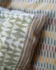 Vivia Cushion Cover, and Sofia Cushion Cover – A refined stack of handwoven silk and cotton cushion covers, each showcasing intricate craftsmanship and timeless design. The Mehira Silk Cushion Cover features a luminous weave with geometric accents, the Vivia Cushion Cover presents a soft herringbone-inspired pattern in earthy tones, and the Sofia Cushion Cover blends traditional motifs with delicate stripes. Perfectly layered, these cushions add depth, texture, and elegance to any spa